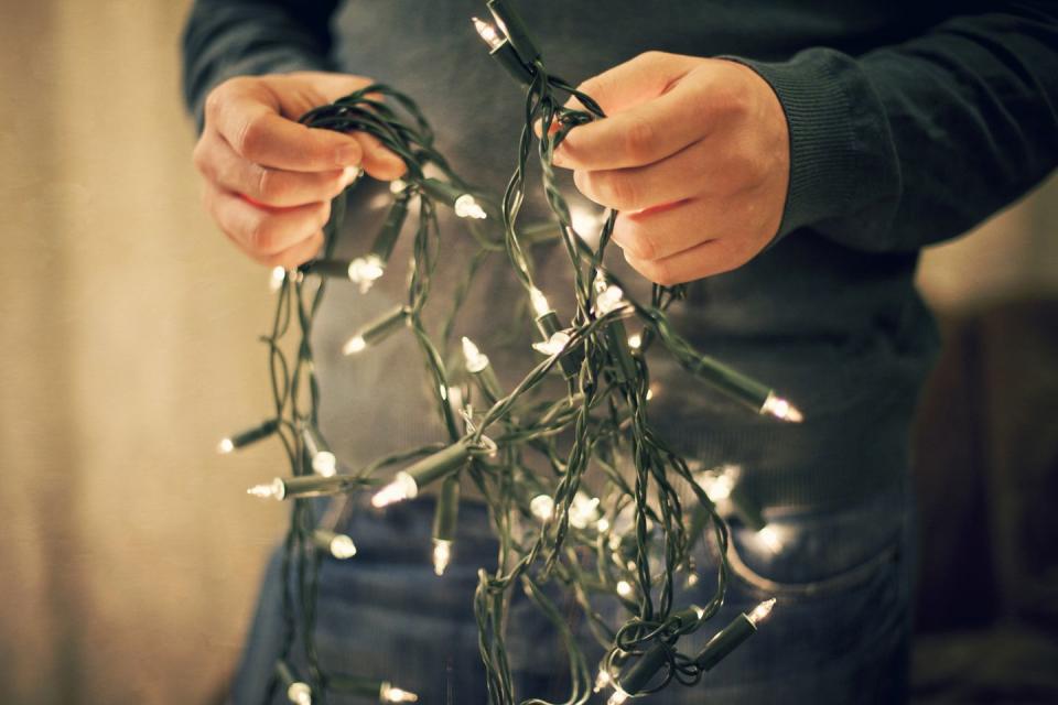 man holding fairy lights