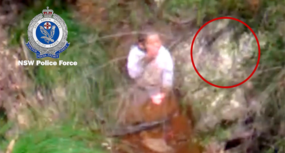 Rescue helicopter image of the boy sipping water from a creek. 