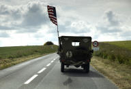 In this photo taken on Thursday, June 4, 2020, a US flag flies on the back of a WWII era US Army Jeep in Grandcamp Maisy, Normandy, France. In sharp contrast to the 75th anniversary of D-Day, this year's 76th will be one of the loneliest remembrances ever, as the coronavirus pandemic is keeping nearly everyone from traveling. (AP Photo/Virginia Mayo)