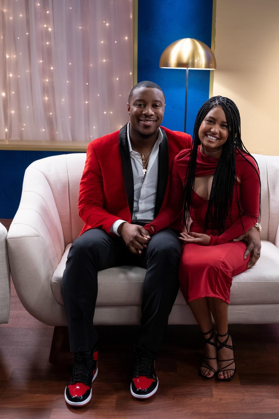 Jarrette Jones and Iyanna McNeely sitting on a couch smiling for a photo