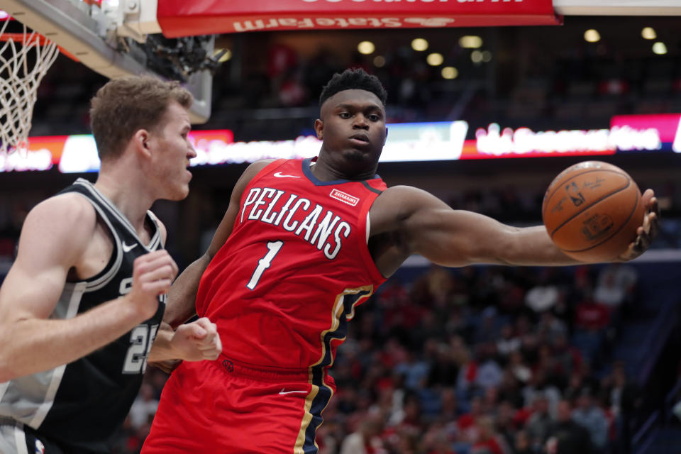 New Orleans Pelicans forward Zion Williamson (1) pulls in a rebound against San Antonio Spurs center Jakob Poeltl (25) in the second half of an NBA basketball game in New Orleans, Wednesday, Jan. 22, 2020. The Spurs won 121-117. (AP Photo/Gerald Herbert)
