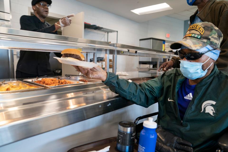 Chef Lorenzo Richardson of the Michigan Veterans Foundation, left, dishes up lunch to homeless veterans including temporarily homeless Army Ranger veteran John Bennett, 68, Detroit on Tuesday, Aug. 29, 2023.