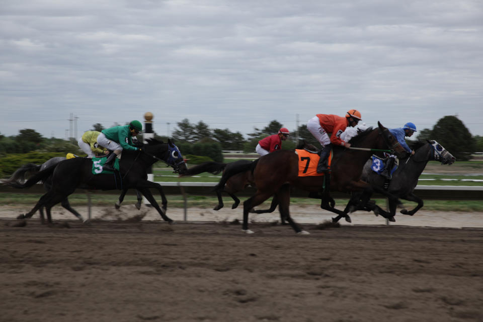 Racehorses charge toward the finish line at Fonner Park in Grand Island, Nebraska, on Friday, May 20, 2022. Horse tracks have been struggling for decades, but after Nebraska legalized casino gambling at the state's six licensed facilities, there's suddenly a lot of interest in them and some communities want to build their own. (AP Photo/Grant Schulte)