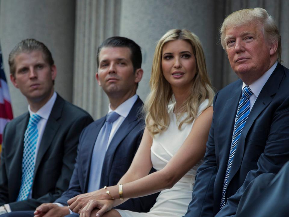 Donald Trump, right, sits with his children, from left, Eric Trump, Donald Trump Jr., and Ivanka Trump during a groundbreaking ceremony for the Trump International Hotel on July 23, 2014, in Washington.