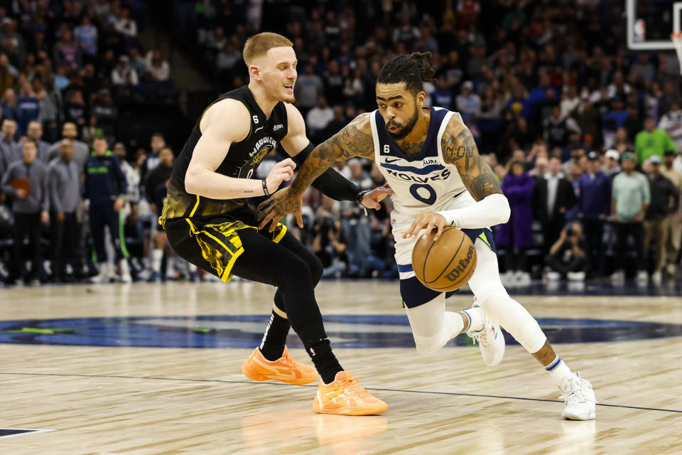 MINNEAPOLIS, MN - FEBRUARY 01: D'Angelo Russell #0 of the Minnesota Timberwolves drives to the basket while Donte DiVincenzo #0 of the Golden State Warriors defends in the fourth quarter of the game at Target Center on February 01, 2023 in Minneapolis, Minnesota. The Timberwolves defeated the Warriors 119-114 in overtime. NOTE TO USER: User expressly acknowledges and agrees that, by downloading and or using this Photograph, user is consenting to the terms and conditions of the Getty Images License Agreement. (Photo by David Berding/Getty Images)