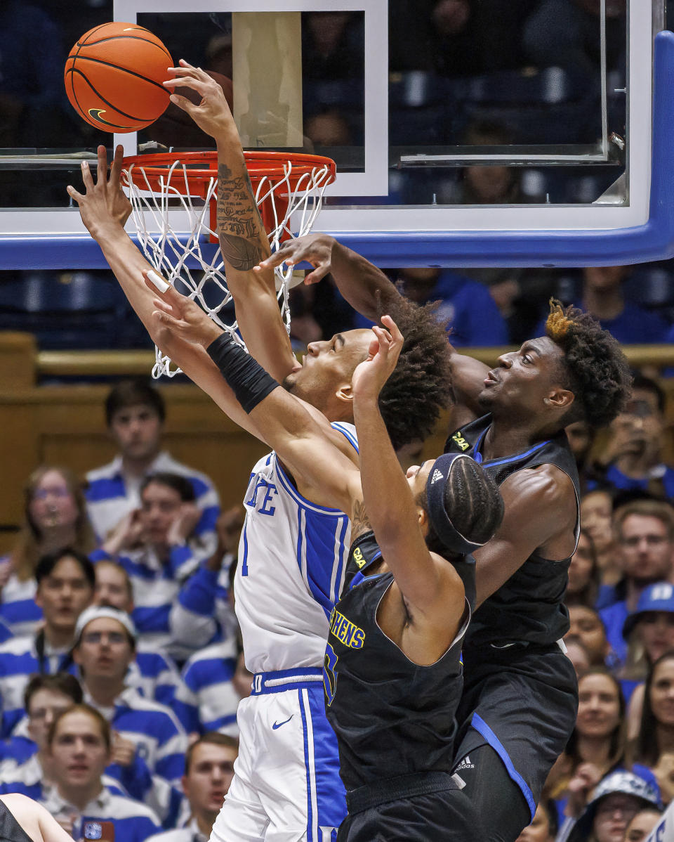 Duke's Dereck Lively II (1) is fouled as he attempts to shoot ahead of Delaware's Jameer Nelson Jr., center, and Ebby Asamoah, right, during the first half of an NCAA college basketball game in Durham, N.C., Friday, Nov. 18, 2022. (AP Photo/Ben McKeown)