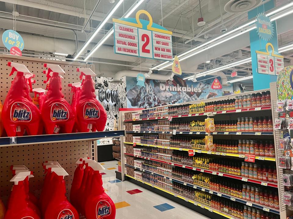 Inside the Omega Mart grocery store aisles. Cleaners and sauces are on the walls.