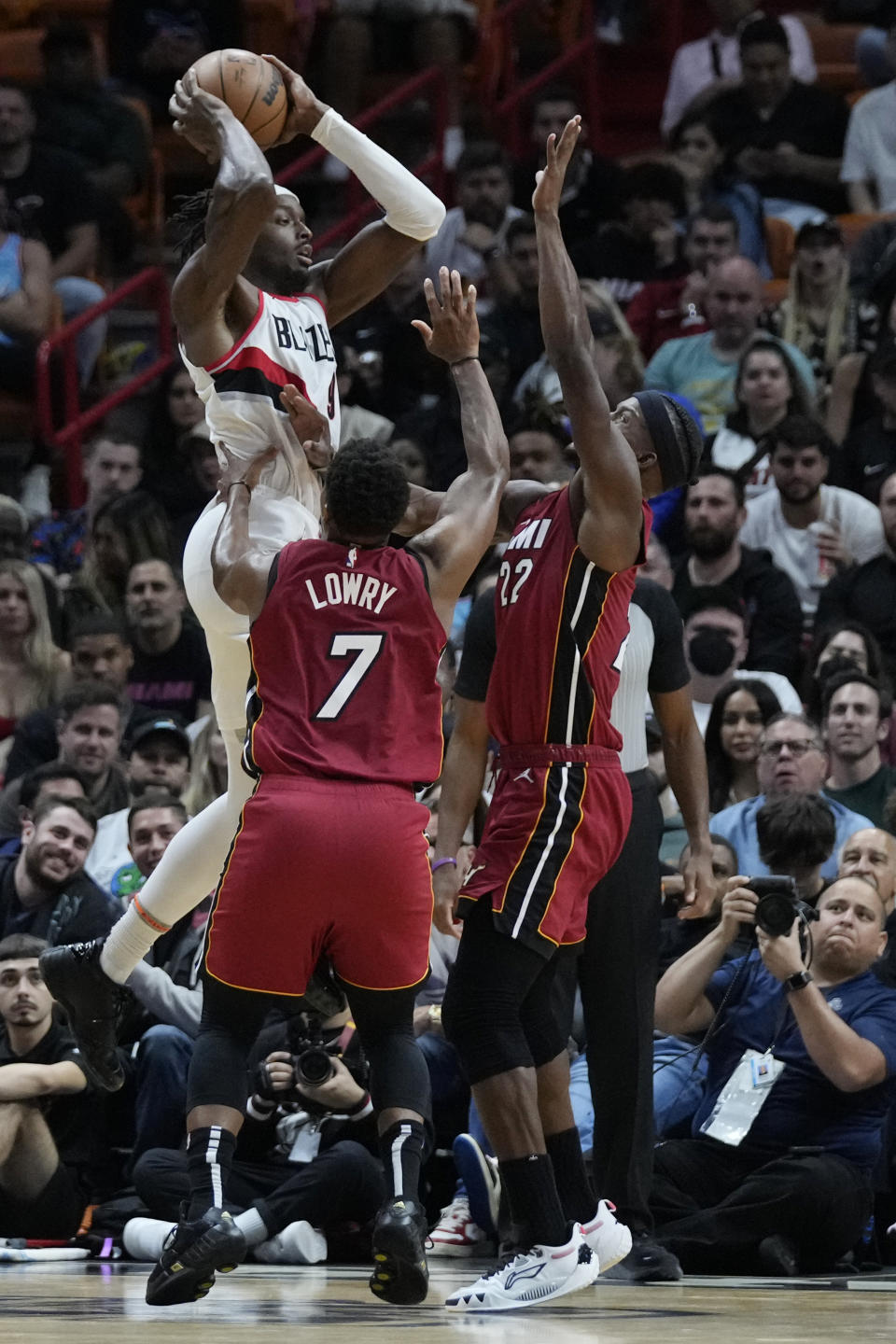 Portland Trail Blazers forward Jerami Grant (9) takes a shot against Miami Heat forward Jimmy Butler (22) and guard Kyle Lowry (7) during the second half of an NBA basketball game, Monday, Nov. 7, 2022, in Miami. (AP Photo/Wilfredo Lee)