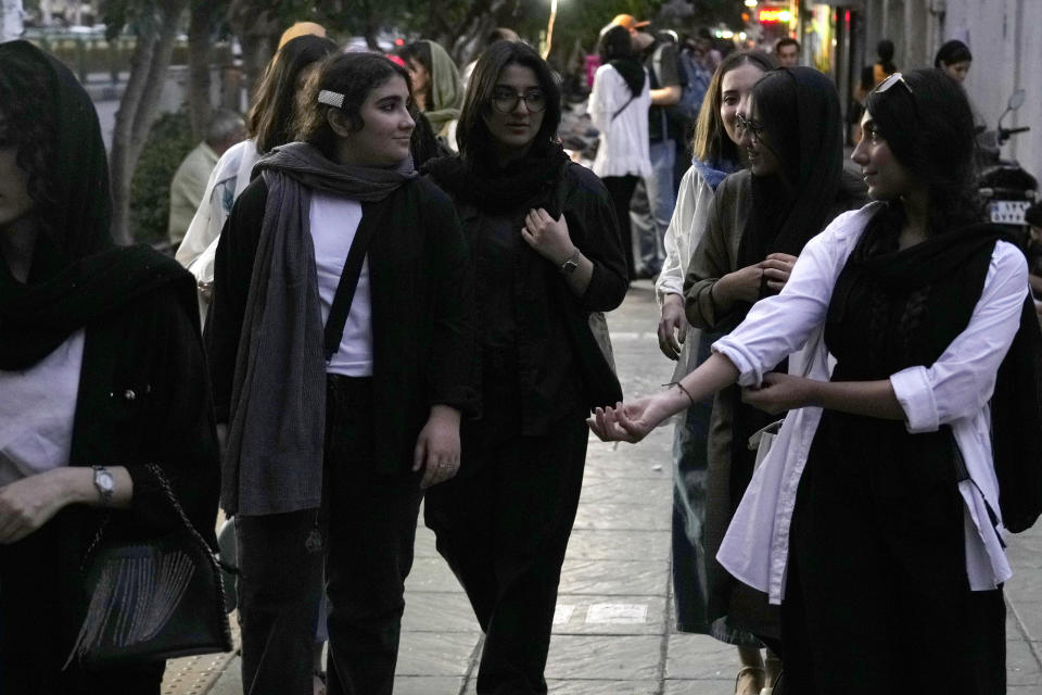 Iranian women without wearing their mandatory Islamic headscarf walk in downtown Tehran, Iran, Monday, June 10, 2024. (AP Photo/Vahid Salemi)