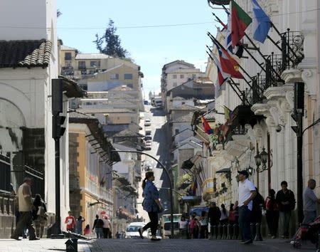 Pedestrians walk by the main square in Quito, Ecuador July 4, 2015. REUTERS/Jose Miguel Gomez