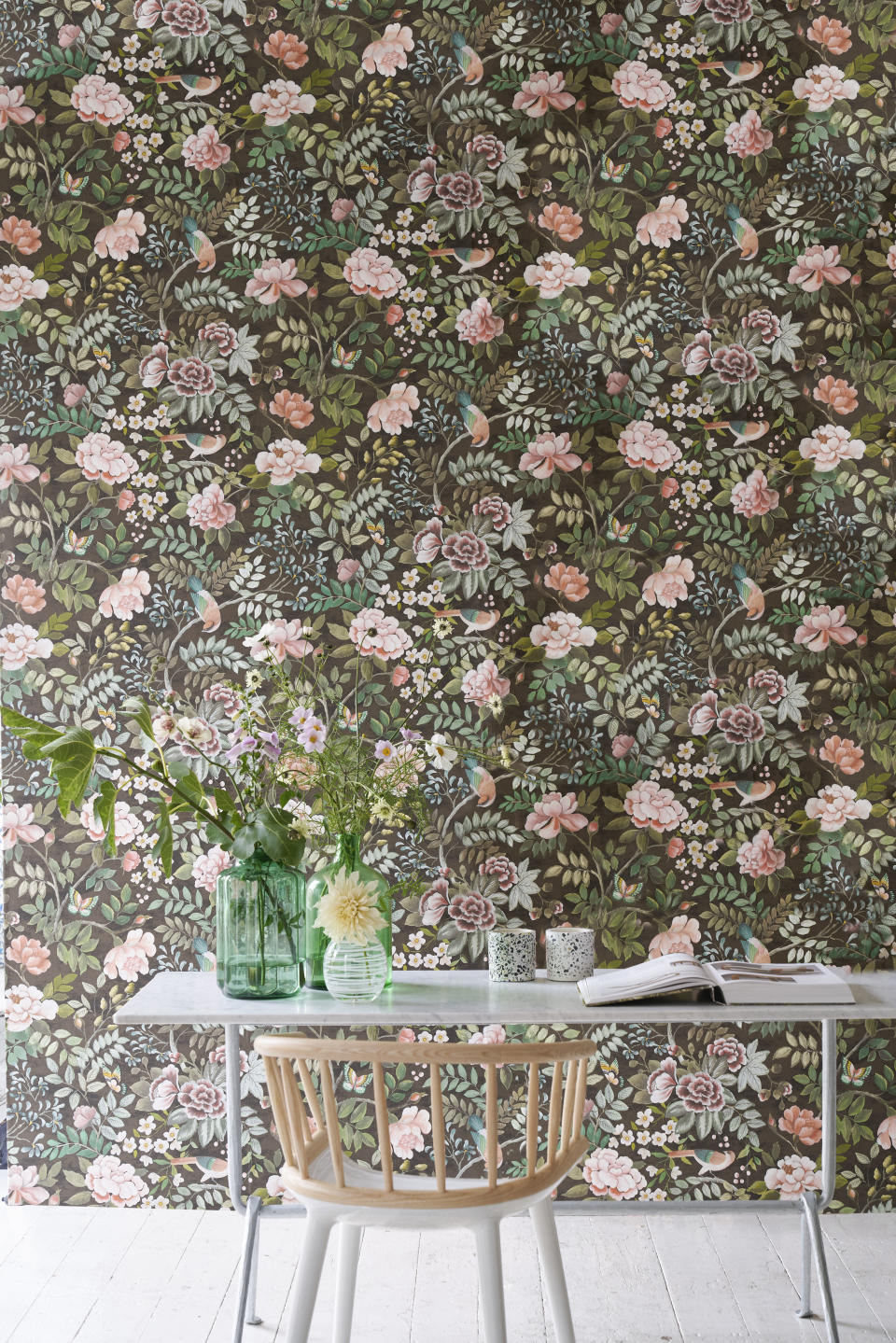 office space with floral wallpaper, white floorboards, desk, chair, vases of flowers