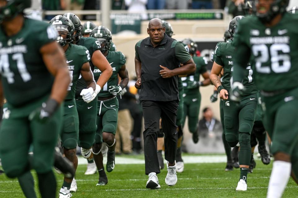 Michigan State head coach Mel Tucker, center, and the team take the field before the game against Minnesota Sept. 24 at Spartan Stadium in East Lansing. Tucker said running back Elijah Collins has earned every rep he's received during games because of how consistent he is at practice.