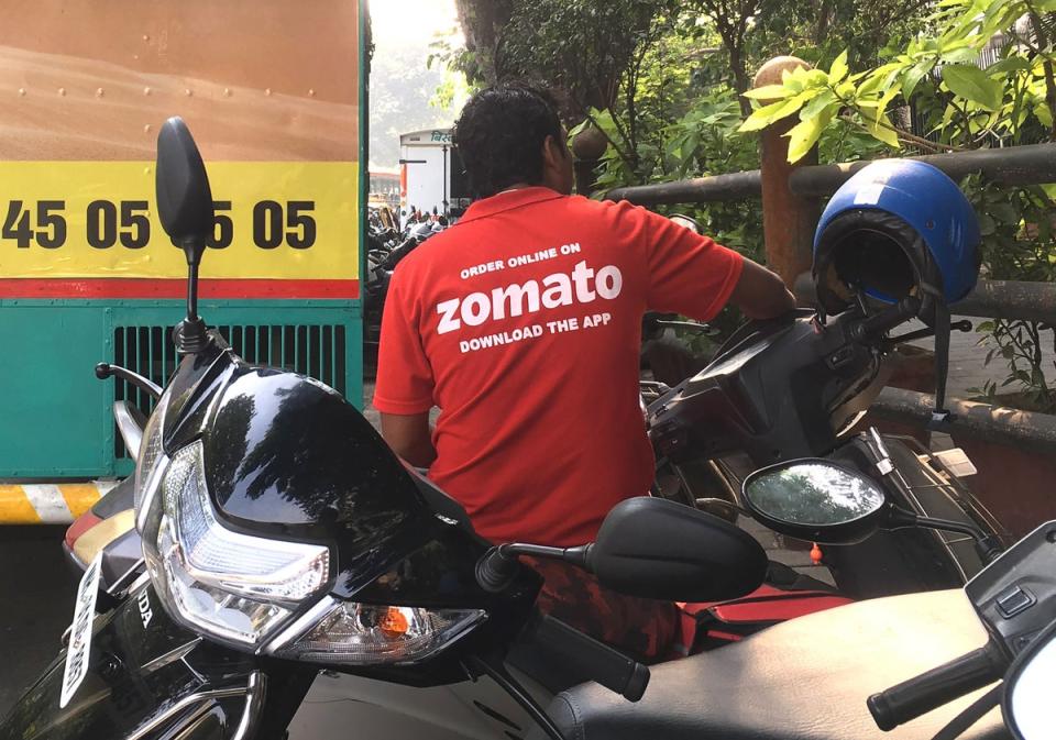 In this photo taken on 24 December 2018, an Indian delivery man working with the food delivery app Zomato sits on his bike in a business district in Mumbai. (AFP via Getty Images)