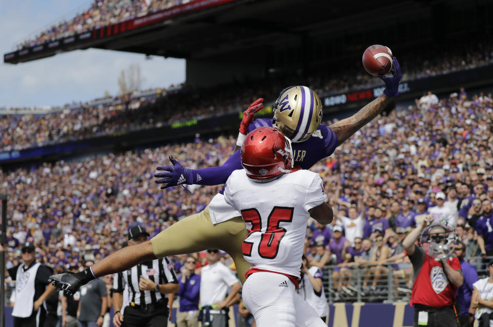 Washington's Aaron Fuller makes a one-handed catch for a touchdown over Eastern Washington's Darreon Moore (26) in the first half of an NCAA college football game Saturday, Aug. 31, 2019, in Seattle. (AP Photo/Elaine Thompson)