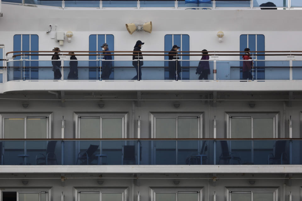 A group of quarantined passengers exercise on the Diamond Princess cruise ship Saturday, Feb. 15, 2020, in Yokohama, near Tokyo. A viral outbreak that began in China has infected more than 67,000 people globally. The World Health Organization has named the illness COVID-19, referring to its origin late last year and the coronavirus that causes it. (AP Photo/Jae C. Hong)