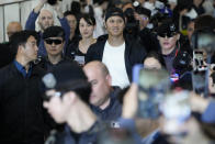 Los Angeles Dodgers Shohei Ohtani, center, walks with his wife Mamiko Tanaka, center left, through a terminal during the baseball team's arrival at Incheon International Airport, Friday, March 15, 2024, in Incheon, South Korea, ahead of the team's baseball series against the San Diego Padres. (AP Photo/Ahn Young-joon)