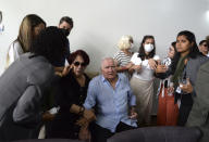 The parents, center, of Indigenous expert Bruno Pereira attend the funeral of their son, at the Morada da Paz cemetery, in Recife, Pernambuco state, Friday, June 24, 2022. Pereira was killed in the Amazon region with the British journalist Dom Phillips. (AP Photo/Teresa Maia)