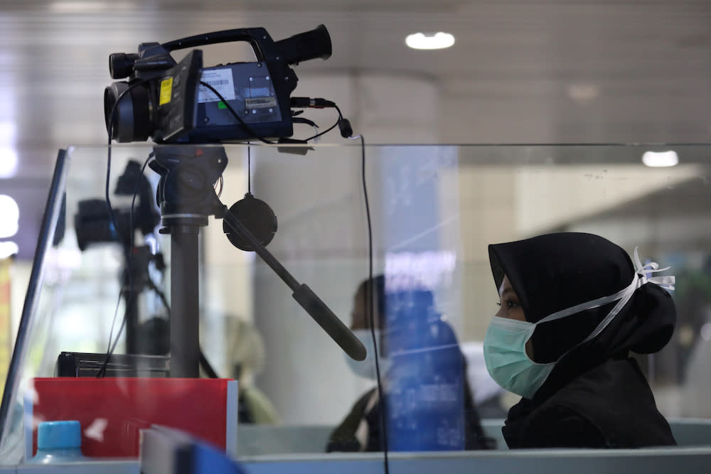 A Malaysian health quarantine officer waits for passengers at a thermal screening point at the international arrival terminal of Kuala Lumpur International Airport in Sepang. — Reuters pic