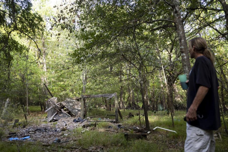 Fred Boyum looks at the remains of a home where one of his friends used to live in the Sam Houston Lake Estates neighborhood on August 22, 2023.