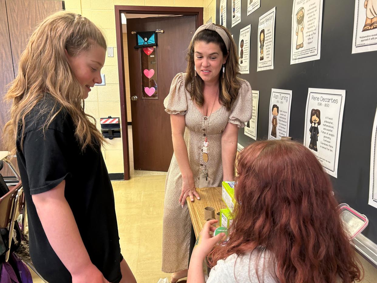 Licking Heights Central Intermediate fifth grade advanced math teacher Jessica Tonstad, center, talks with students Isabella Foster, left, and Allison Waddell, right, about their math project on May 1. Tonstad is vying for the title of America's Favorite Teacher in a nationwide contest, held by Reader's Digest and the non-profit Teach for America.