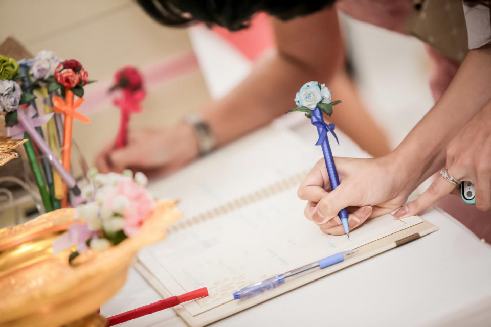 People sign a wedding guest book