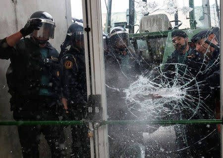 Spanish Civil Guard officers break through a door at a polling station for the banned independence referendum where Catalan President Carles Puigdemont was supposed to vote in Sant Julia de Ramis, Spain October 1, 2017. REUTERS/Juan Medina