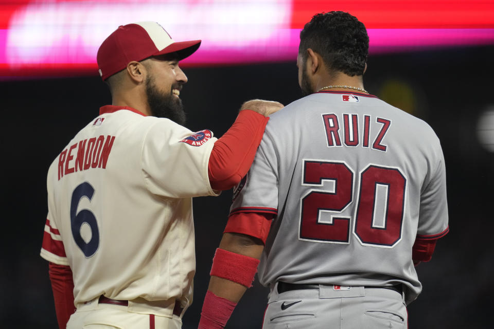 Los Angeles Angels third baseman Anthony Rendon (6) and Washington Nationals' Keibert Ruiz (20) share a moment at third base during the fourth inning of a baseball game in Anaheim, Calif., Tuesday, April 11, 2023. (AP Photo/Ashley Landis)