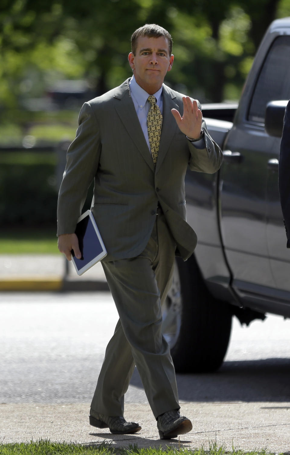 Former Anheuser-Busch CEO August Busch IV waves as he enters the Civil Court building before testifying in a gender discrimination lawsuit Tuesday, May 6, 2014, in St. Louis. Francine Katz, former vice president of communications and consumer affairs for the maker of Budweiser, Bud Light and other beers, is suing Anheuser-Busch for gender discrimination. (AP Photo/Jeff Roberson)