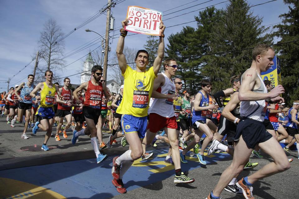 Runners in the first wave of 9,000 cross the start line of the 118th Boston Marathon Monday, April 21, 2014 in Hopkinton, Mass. (AP Photo/Stephan Savoia)