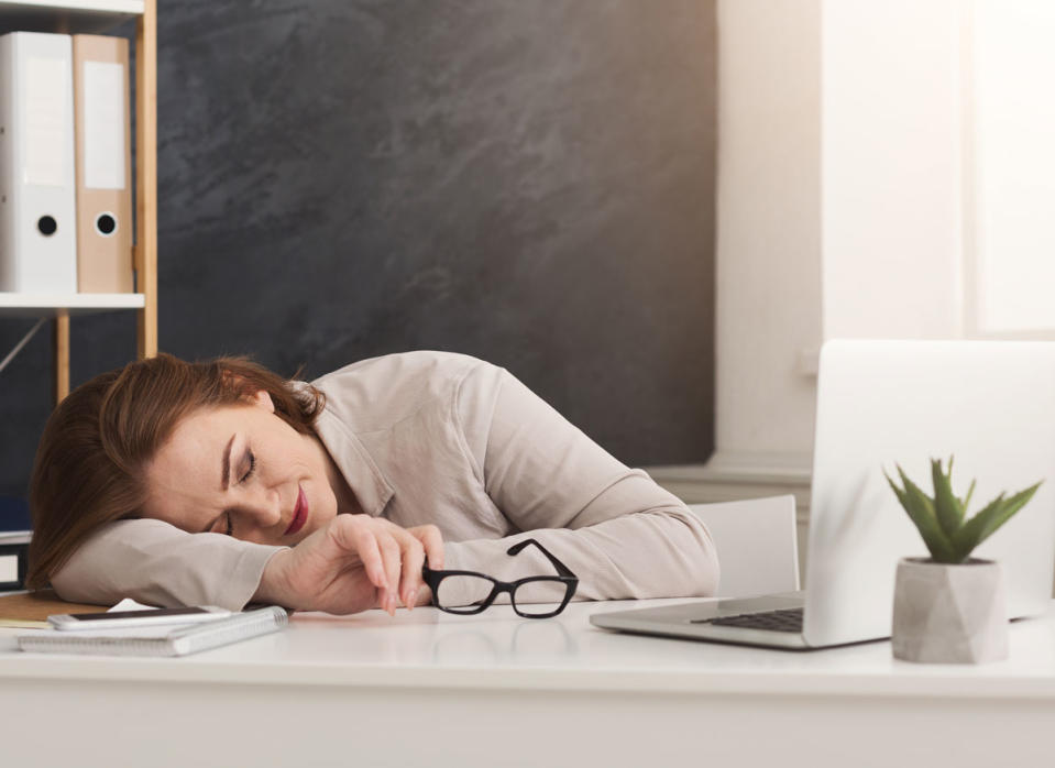 tired woman lying down on desk at work