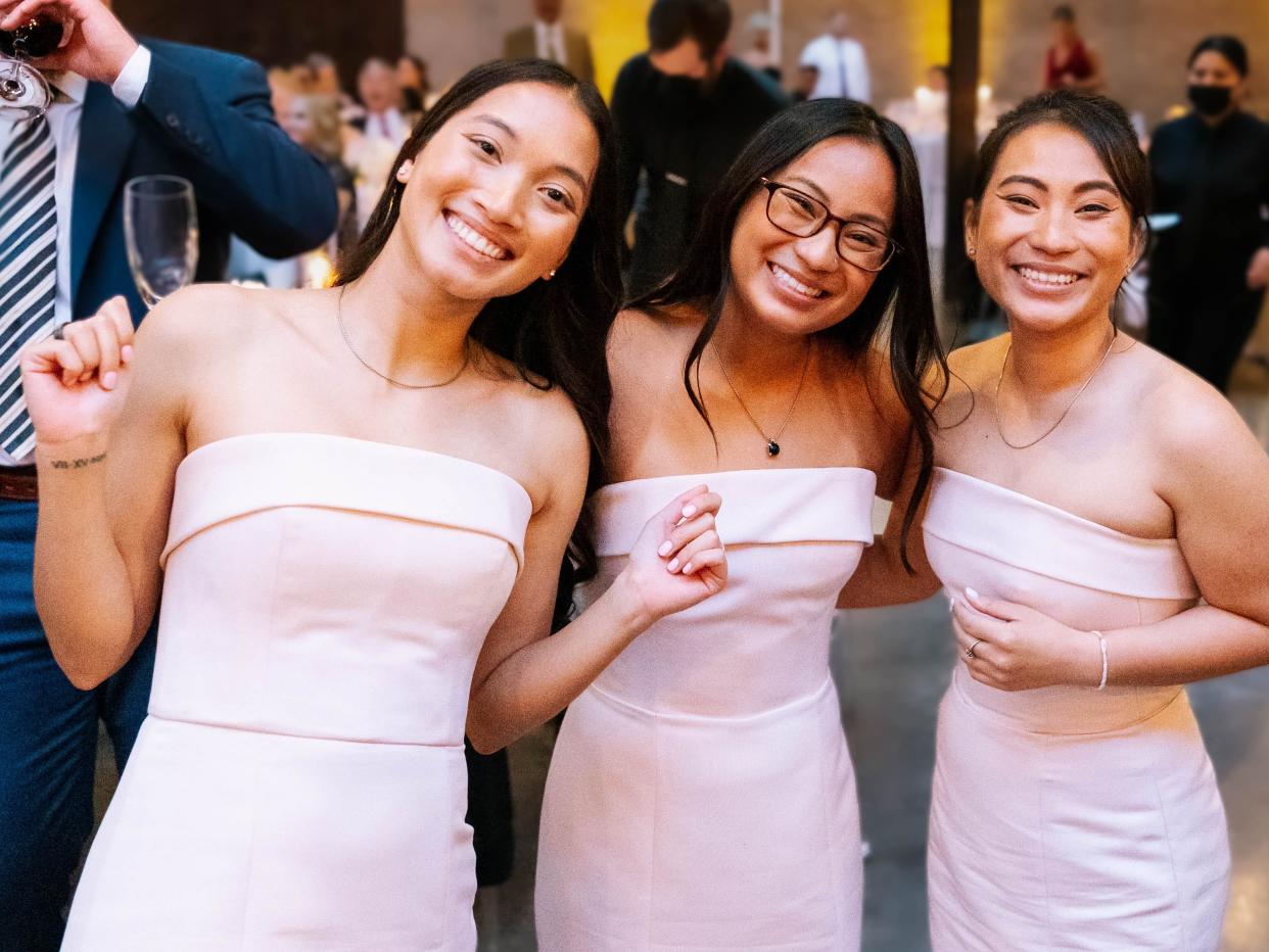 Identical twins Isabella Solimene and Ha Nguyen are pictured with their best friend, Olivia Solimene, at a family wedding.
