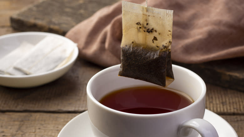 pulling tea bag out of cup