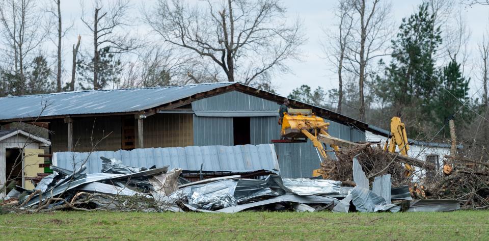 An emergency worker inspects damage seen on Lee County Road 11 near the intersection of Lee County Road 39, Monday, March 4, 2019, in Beauregard, Ala.