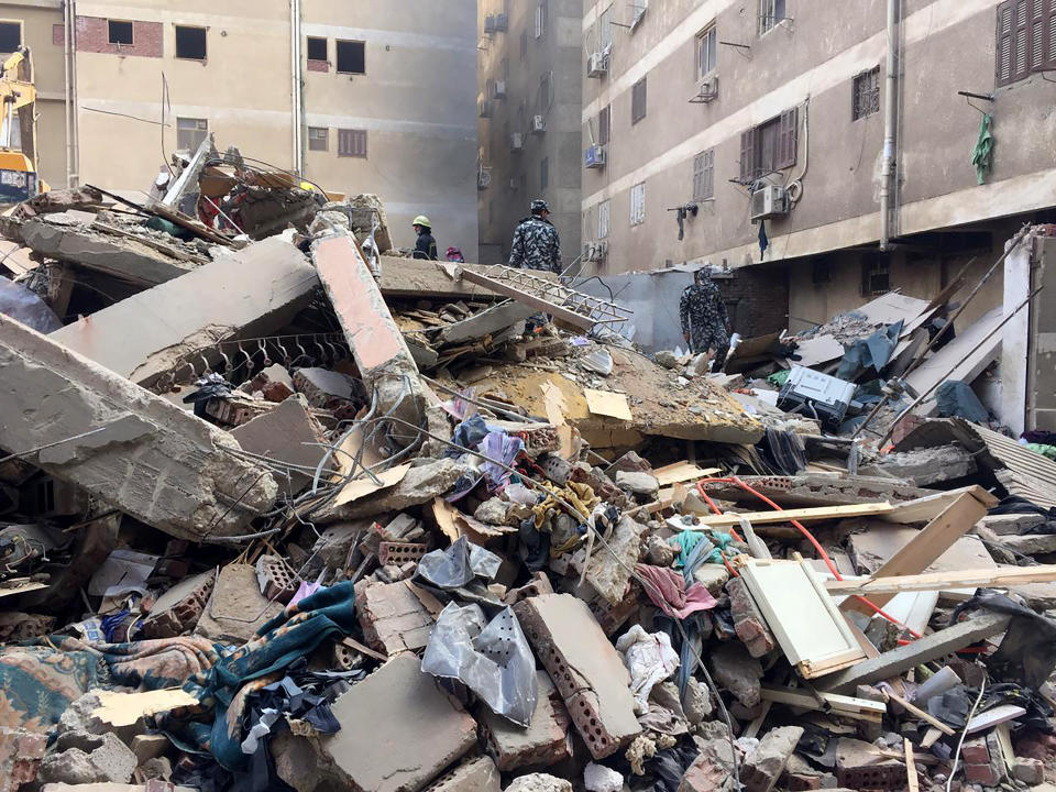 Emergency workers sift through the rubble of a collapsed apartment building in the el-Salam neighborhood, Saturday, March 27, 2021, in Cairo, Egypt. A nine-story apartment building collapsed in the Egyptian capital early Saturday, killing numerous people and injuring dozen more, said Khalid Abdel-Al, the administrative head of the Cairo government. (AP Photo/Mohamed Salah)