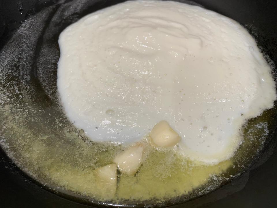 White, creamy cauliflower mix with butter in garlic in a pan