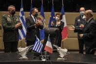 French Defense Minister Florence Parly, center, her Greek counterpart Nikos Panagiotopoulos, second left, and the officials applaud after signing the Rafale warplane deal in Athens, Monday, Jan. 25, 2021. Greece is due to sign a 2.3 billion euro ($2.8 billion) deal with France Monday to purchase 18 Rafale fighter jets to address tension with neighbor Turkey. (Louisa Gouliamaki/Pool via AP)