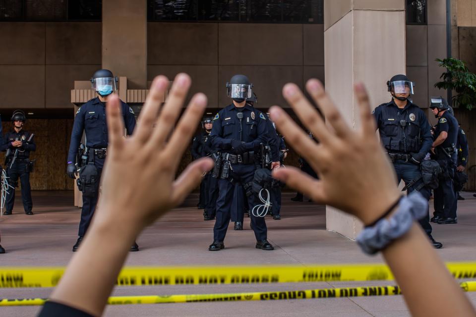 Police stand guard during a peaceful protest over the death of George Floyd, in Anaheim, Calif. 