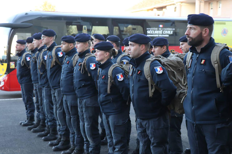 This photo provided Tuesday Feb.7, 2023 by the French Interior Ministry shows rescue workers lining up before boarding a bus for the Charles de Gaulle airport, north of Paris, Monday, Feb.6, 2023 in Nogent-le-Rotrou, central France. Countries around the world dispatched teams to assist in the rescue efforts, and Turkey's disaster management agency said more than 24,400 emergency personnel were now on the ground. But with such a wide swath of territory hit by Monday's earthquake and nearly 6,000 buildings confirmed to have collapsed in Turkey alone, their efforts were spread thin. (Ministere de l'Interieur via AP)