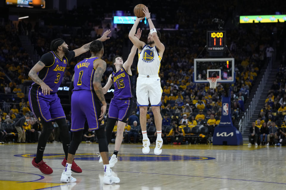 Golden State Warriors guard Klay Thompson shoots while defended by Los Angeles Lakers forward Anthony Davis (3), left, guard D'Angelo Russell (1), center, and guard Austin Reaves (15) during the second half of Game 2 of an NBA basketball Western Conference semifinal game, Thursday, May 4, 2023, in San Francisco. (AP Photo/Godofredo A. Vásquez)