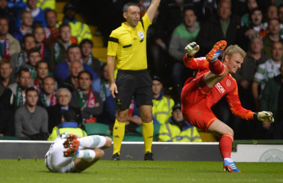 Celtic's Mikael Lustig (L) sends Ajax's goalkeeper Jasper Cillessen flying during their Champions League soccer match at Celtic Park Stadium in Scotland October 22, 2013. REUTERS/Russell Cheyne (BRITAIN - Tags: SPORT SOCCER)