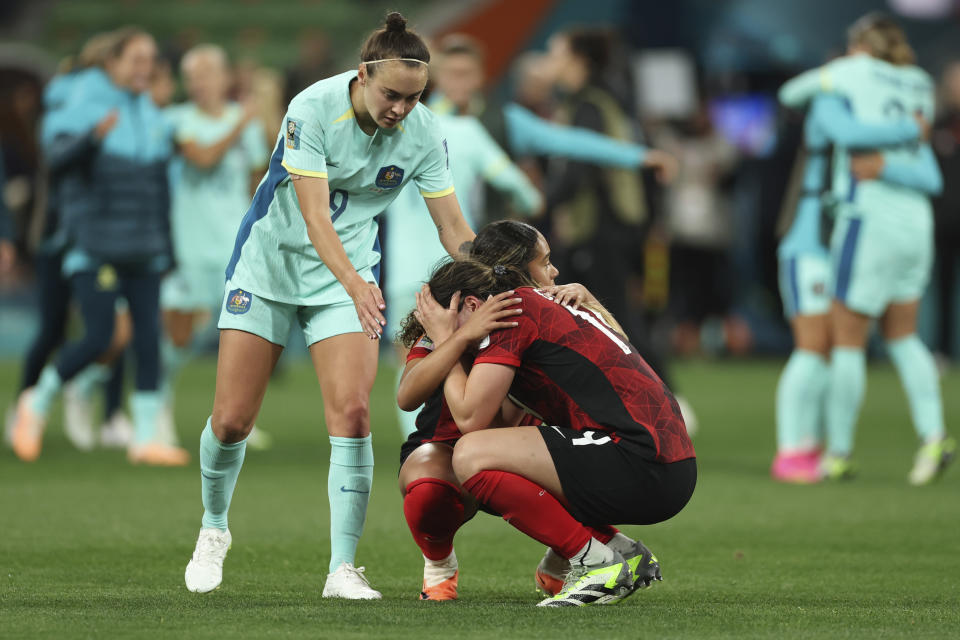 Australia's Caitlin Foord, left, reaches out to Canada's Vanessa Gilles and Olivia Smith at the end of the Women's World Cup Group B soccer match between Australia and Canada in Melbourne, Australia, Monday, July 31, 2023. Australia won 4-0. (AP Photo/Victoria Adkins)