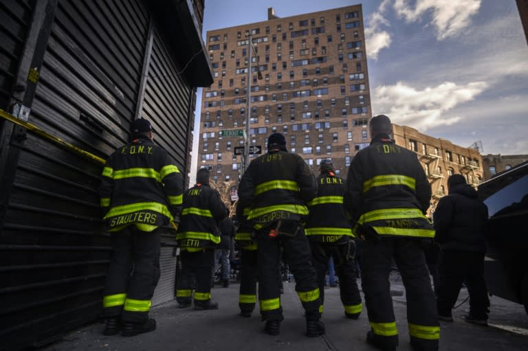 Des pompiers devant l'immeuble qui a pris feu dans le quarteir du Bronx à New York, le 10 janvier 2022 (AFP/Ed JONES)