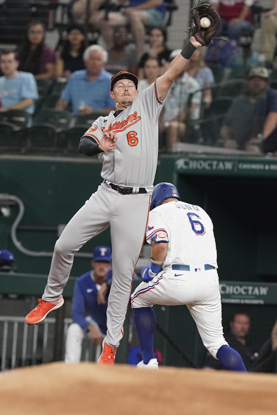 Baltimore Orioles first baseman Ryan Mountcastle (6) reaches for the throw as Texas Rangers' Josh Jung (6) reaches first base safely during the second inning of a baseball game in Arlington, Texas, Monday, April 3, 2023. (AP Photo/LM Otero)