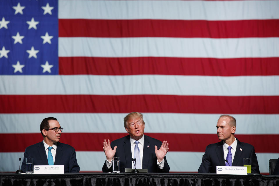 Treasury Secretary Steve Mnuchin, left, and Boeing CEO Dennis Muilenburg, right, listen as President Donald Trump speaks during a roundtable discussion on tax policy at the Boeing Company, Wednesday, March 14, 2018, in St. Louis. (AP Photo/Evan Vucci)