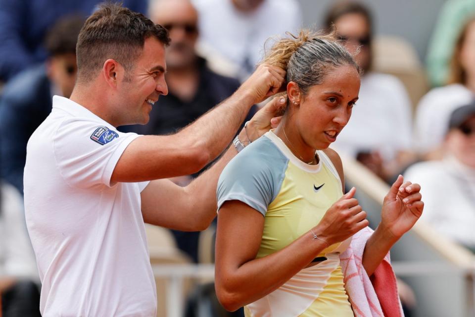 Chair umpire Jaume Campistol helps Madison Keys untangle her necklace (Jean-Francois Badias/AP) (AP)