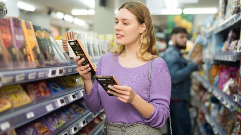 woman comparing chocolate bars