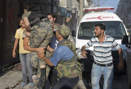 Un rebelde sirio carga con un compañero herido para llevarlo al hospital el sábado 22 de septiembre en Alepo. La guerra, ha dejado más de 29.000 muertos en 18 meses, según el Observatorio Sirio de Derechos Humanos (OSDH). (AFP | Miguel Medina)