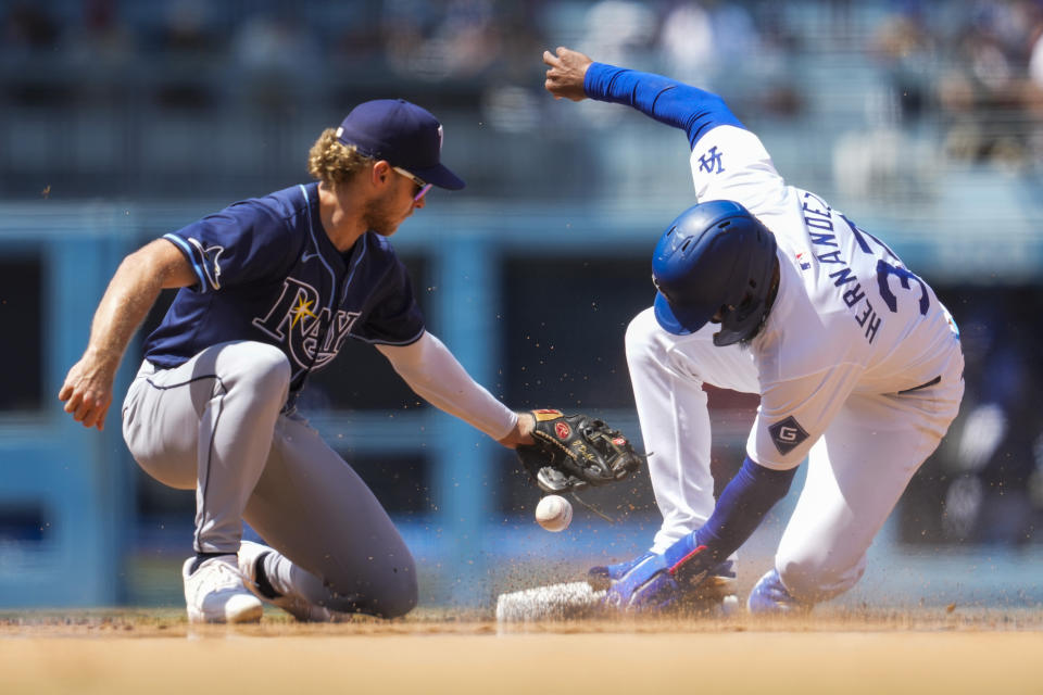 Los Angeles Dodgers' Teoscar Hernández, right, steals second ahead of a throw to Tampa Bay Rays shortstop Taylor Walls during the sixth inning of a baseball game in Los Angeles, Sunday, Aug. 25, 2024. (AP Photo/Ashley Landis)