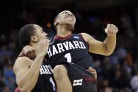 Harvard's Siyani Chambers, right, leaps into the arms of teammate Brandyn Curry after the team beat Cincinnati in the second round of the NCAA college basketball tournament in Spokane, Wash., Thursday, March 20, 2014. Harvard won 61-57. (AP Photo/Elaine Thompson)