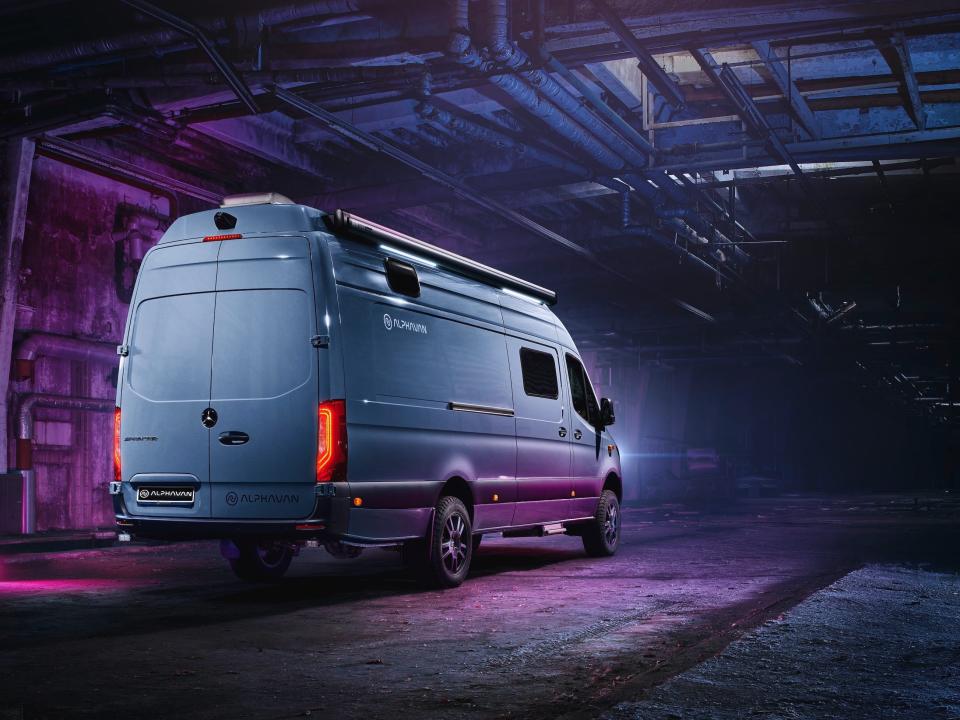 A rendering of the rear of the Alphavan in a purple and blue underground space.